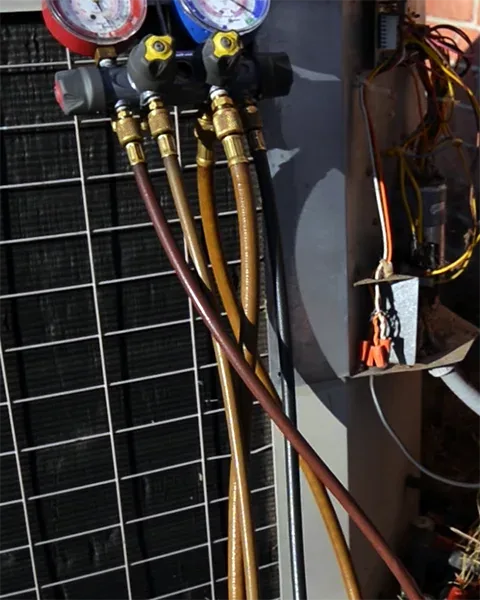 HVAC gauge manifold hooked up to an outdoor AC unit during maintenance