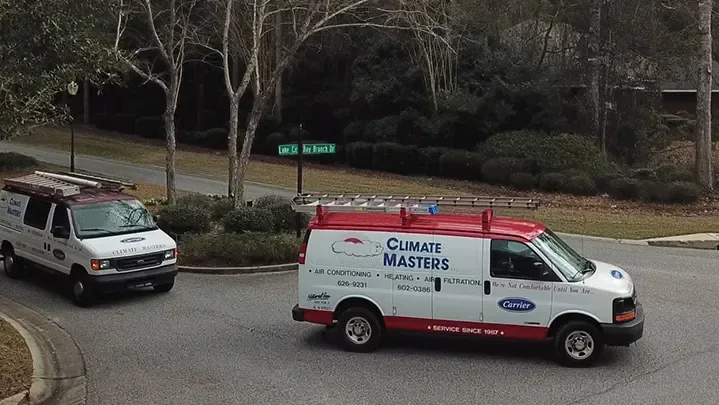 Two Climate Masters service vans at a residential road junction