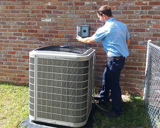 Climate Masters technician in Spanish Fort inspecting an outdoor air conditioning unit disconnect box