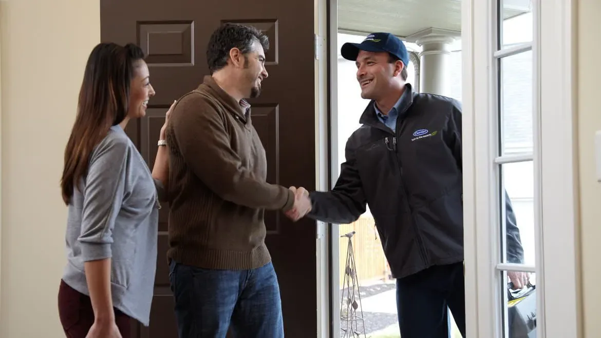 Climate Masters service technician greeting homeowners at their front door