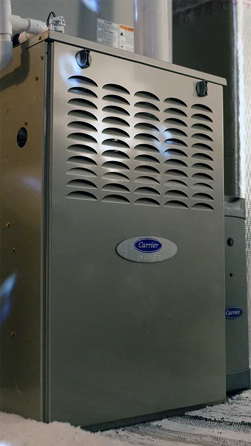 A Carrier gas furnace installed in a home, the kind Climate Masters, Inc. technicians service for furnace repair across Mobile and Baldwin County