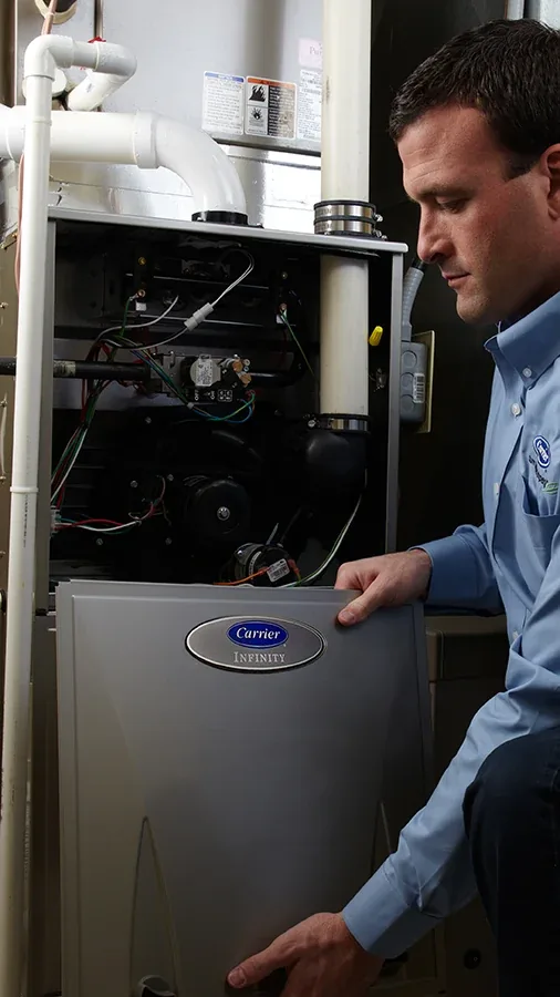 Technician performing repairs and tune-up on a home furnace