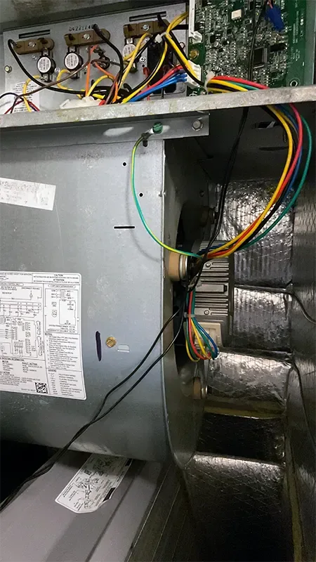 The inside of a gas furnace with its cover removed during furnace repair in Spanish Fort, showing the blower wheel, control board and wiring