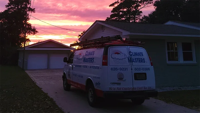 A Climate Masters, Inc. service van parked in a residential driveway at dusk