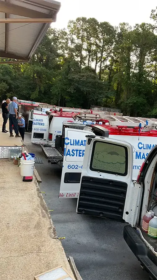 Several Climate Masters vans lined up under a canopy at our Spanish Fort headquarters for regional HVAC service areas dispatch