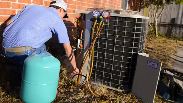 Climate Masters Inc. technician performing repairs on a outdoor AC unit | AC Maintenance | Climate Masters Inc.