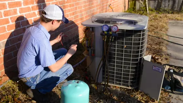 Climate Masters Inc. technician performing maintenance on a outdoor AC unit | AC Maintenance | Climate Masters Inc.