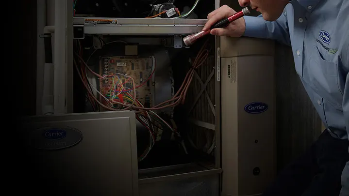 HVAC technician looking at furnace | Climate Masters INC | Heating Repair Near Me | Heating Repair