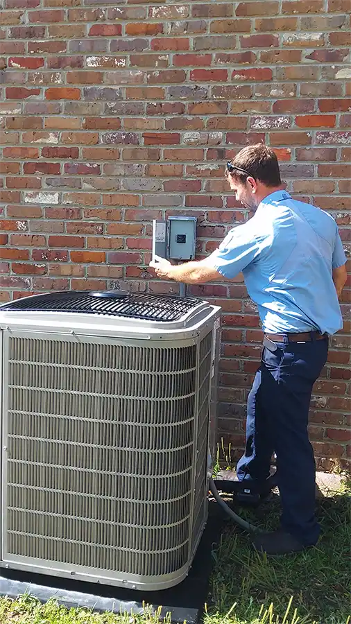 Technician inspecting outside outlet for a outdoor air conditioning unit | HVAC Contractors | Climate Masters Inc.