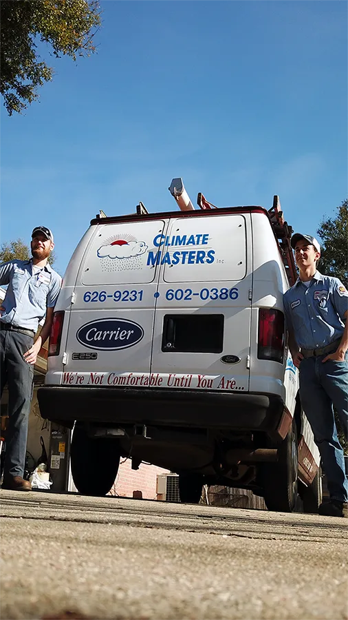 Two HVAC contractors standing beside Climate Masters Inc.'s service van | Home | Climate Masters Inc.