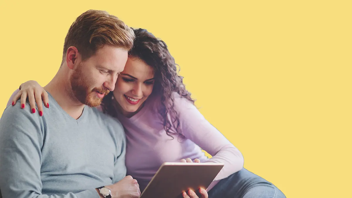 Comfortable couple looking at tablet | Climate Masters & Alabama Power Smart Financing